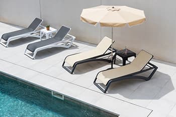 terraza de piscina con tumbona y parasol de garbar