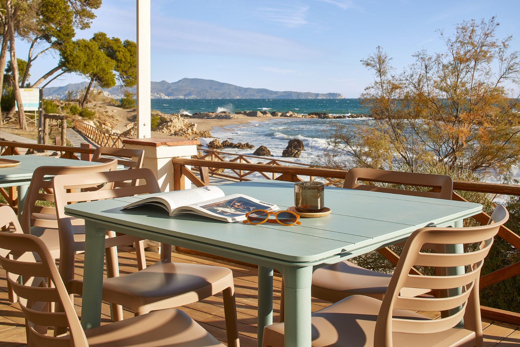 Mesa al sol en una terraza junto al mar con sillas Wind de Garbar